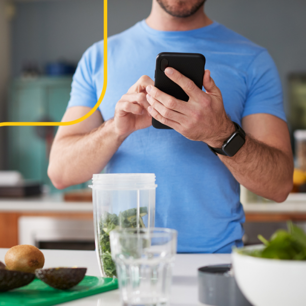 Man checks recipe on phone while making a healthy snack